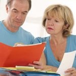 Man and woman read papers about funeral insurance